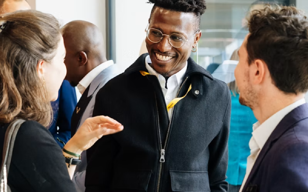 Smiling man in a coat gesturing while talking